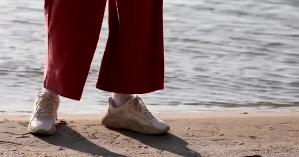 Donna Sneakers Bianche Pantaloni Arancioni Cammina Sulla Sabbia Riva Mare — Video Stock