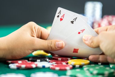 En iyi oyun kartı serisi ve para yongaları tutan el kumar