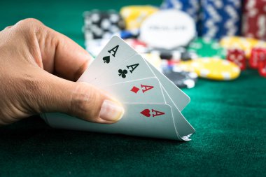 En iyi oyun kartı serisi ve para yongaları tutan el kumar