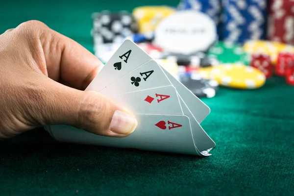 En iyi oyun kartı serisi ve para yongaları tutan el kumar