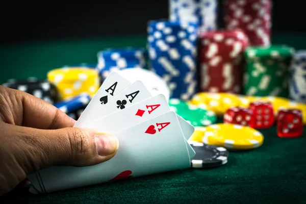 En iyi oyun kartı serisi ve para yongaları tutan el kumar