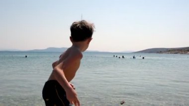 Genç Çocuk Denize Taş Fırlatıyor