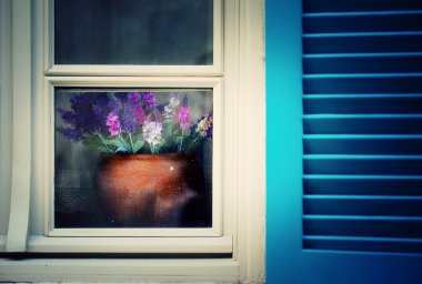Pencerenin yakınındaki tencerede çiçekler
