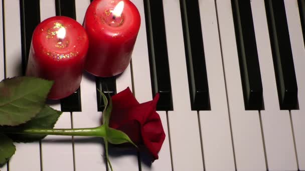 Rose e candela sui tasti del pianoforte — Video Stock