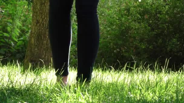 Женщина снимает обувь с травы — стоковое видео