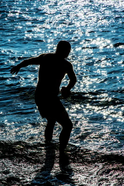 Silhueta homem no mar Fosforescência — Fotografia de Stock