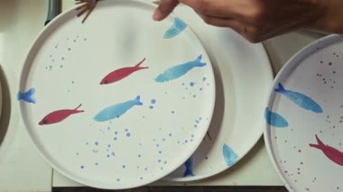 Seramik Stüdyosunda Fırçayla Balık desenli Tabağa Boya Taneleri Sıçratmak 