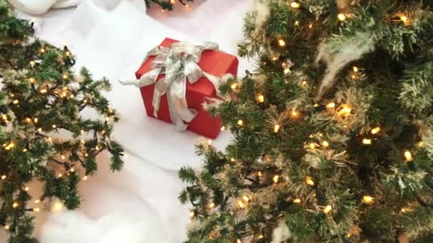 Новорічна подарункова коробка, імітація снігу та дерева з вогнями — стокове відео