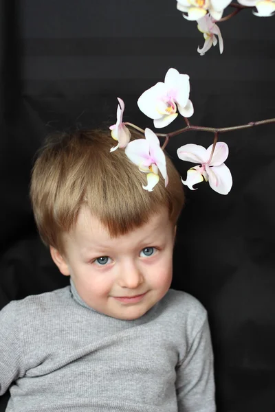 Smiling Handsome boy and orchid flower — Stock Photo, Image