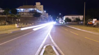 Gece yarısı farların izleriyle ikiye ayrılan bir yolun zamanlaması.