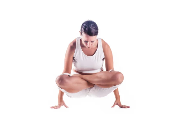 Woman practicing the "Cockerel" yoga posture. Stock Picture