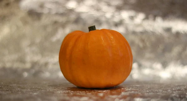 Abóbora de Halloween contra fundo de prata borrada com espaço para cópia — Fotografia de Stock