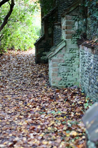 Imagen de retrato de piedra vieja y pared de ladrillo con camino al lado en otoño —  Fotos de Stock