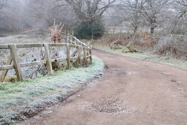 Anglická country scéna v zimě ukazuje ledový pruh s plotem a stromy — Stock fotografie