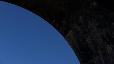 Koyu eskimiş köprü kemeri olan basit mavi gökyüzü arkaplanı