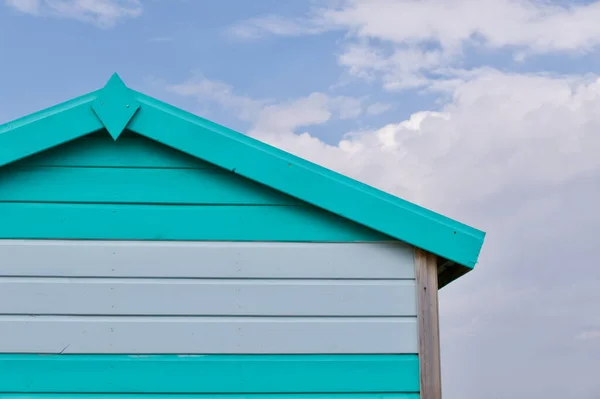 Capanna da spiaggia in legno turchese e bianco contro il cielo nuvoloso blu e bianco — Foto Stock