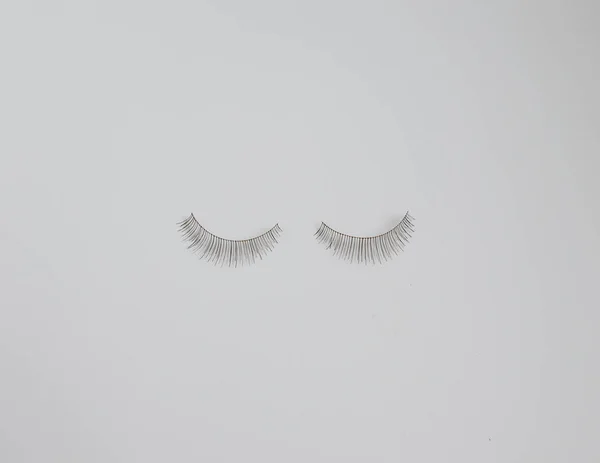 Zwei falsche Wimpern vor schlichtem weißen Hintergrund mit Kopierraum — Stockfoto