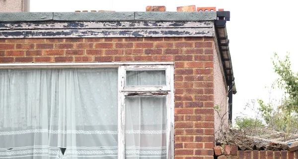 stock image Decaying old building with weathered window frame and peeling paint