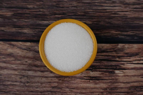 Senapsfärgad skål med socker på träbord med kopieringsutrymme — Stockfoto