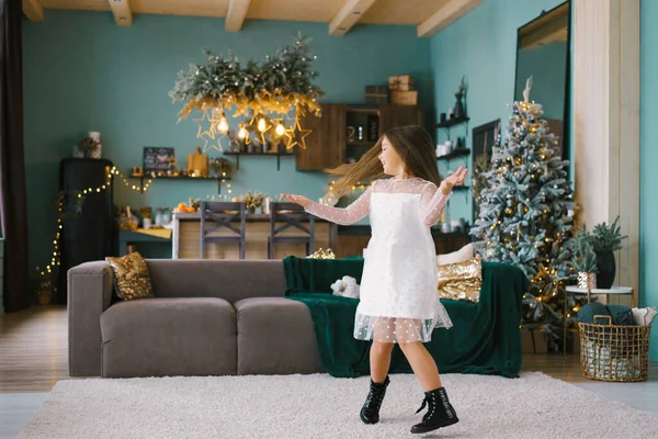 Ένα Χαρούμενο Κοριτσάκι Λευκό Φόρεμα Στριφογυρίζει Μπροστά Από Ένα Χριστουγεννιάτικο — Φωτογραφία Αρχείου