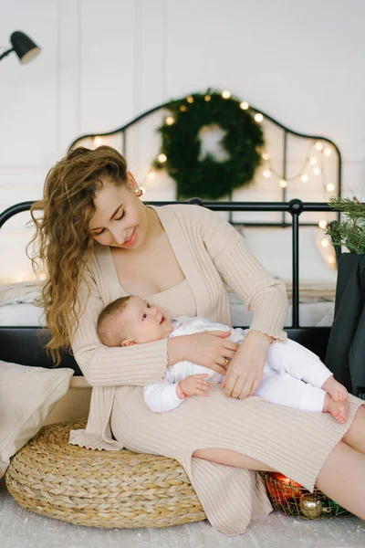 Mãe Bebê Abraçam Fundo Uma Cama Uma Árvore Natal Feriados — Fotografia de Stock