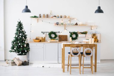 Yeni yıl ve Noel. Noel süslemelerinde İskandinav mutfağı. Mumlar, köknar dalları, ahşap tezgahlar, masa..