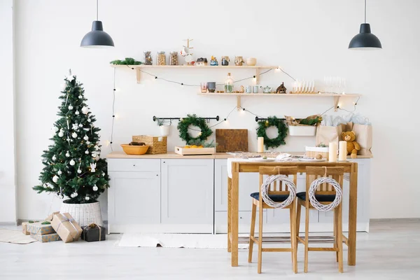 Yeni yıl ve Noel. Noel süslemelerinde İskandinav mutfağı. Mumlar, köknar dalları, ahşap tezgahlar, masa..