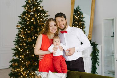 Aile tatilin tadını çıkarıyor. Birlikte ilk Noel 'lerini kutluyorlar. Mutlu aile Noel ağacıyla dolu odada.