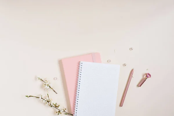 白りんごの花の小枝とピンクのノートとベージュの背景にピンクのペンが入った空白のノートシート コピースペース付きブログの春のコンセプト — ストック写真