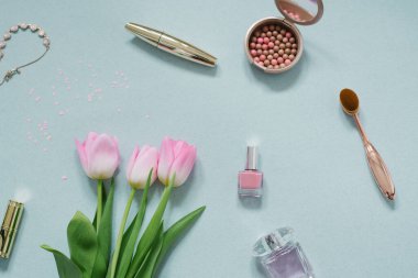 Kozmetik ve güzellik ürünleri kremi, pembe laleler, nane arkaplanlı pembe bir hediye ve konfeti.