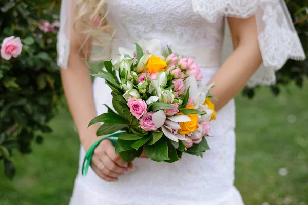 ピンクと黄色のバラと花嫁の手に緑の蘭の繊細な美しい結婚式の花束を閉じる — ストック写真