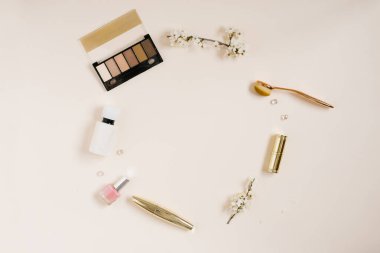 Kozmetik ürünleri olan kadınlar masası, kopyalama alanı olan bir daire çerçevesi, bej arka planda elma çiçekleri. Üst Manzara. Düz yatıyordu. Anneler Günü için çerçeve bileşimi veya bir blog yazarı için