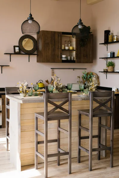 Wooden bar counter with wooden chairs in the interior of the kitchen dining room in the Scandinavian style