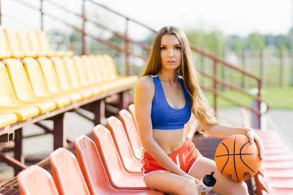 매력적 선수인 밖에서 경기장 의자에 농구공 — 스톡 사진