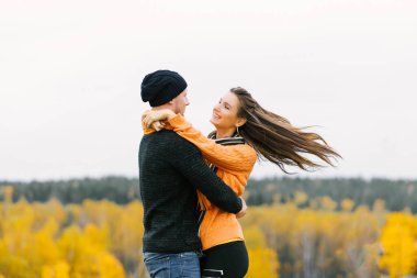 Birbirine aşık genç bir çift, çekici bir kadın ve günlük kıyafetler giyen bir adam sonbahar parkında açık havada yürürken dans edip dönüyorlar. Aşk ilişkileri aile yaşam tarzı kavramı