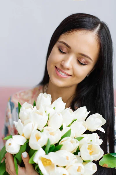 Atractiva Morena Sosteniendo Tulipanes Blancos Con Hermoso Maquillaje Cerca — Foto de Stock