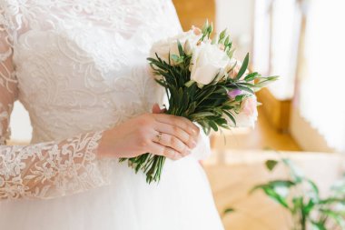 Gelinin elinde zarif, şık bir buket var. Nişan yüzüğü düğünde bir ele takılır.