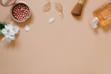 Kozmetik ürünler, dekoratif kozmetik ürünler, parfüm ve çiçekler bej arka planda beyaz bir üst görünüm. Bir moda blogcusu için düz bir yatak. Boşluğu kopyala