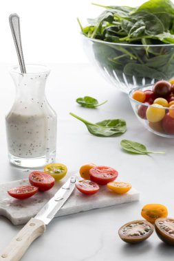 Beyaz arka planda salata için hazırlanan vişneli domateslerin yakın plan görüntüsü..