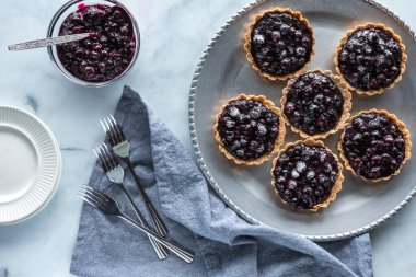 Metal servis tepsisindeki yaban mersinli turtaların üst görünümü paylaşmaya hazır..