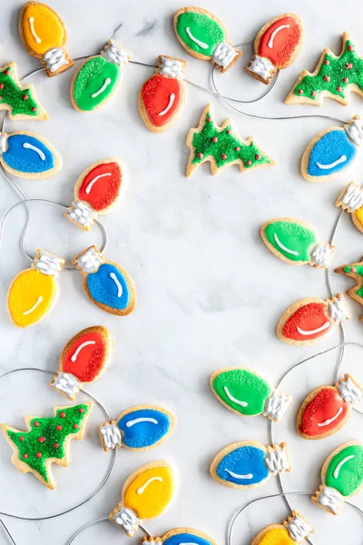 Vánoční žárovky cookies v rámečku s kopírovacím prostorem uprostřed, na světlém pozadí. — Stock fotografie