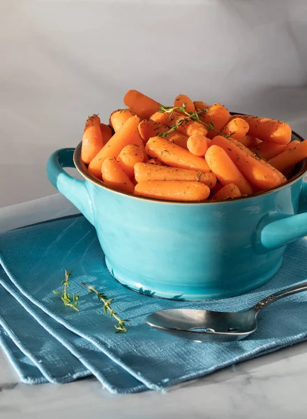 Синя керамічна страва, наповнена вареною дитячою морквою і прикрашена чебрецем . — стокове фото