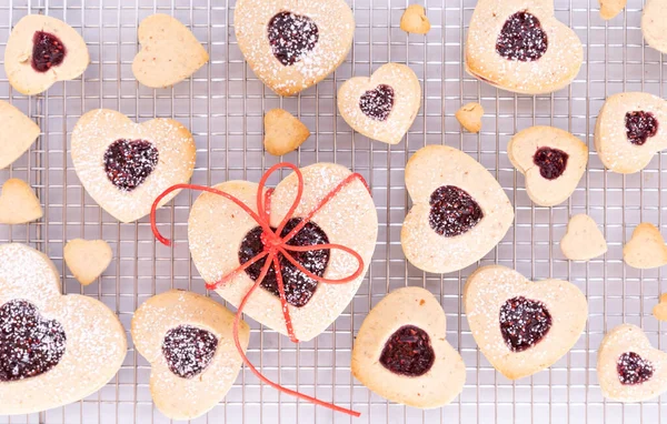 ハート型のトップダウンビューラズベリーが充填されたリンザークッキーは、バレンタインデーのために、冷却ラックに保存します. — ストック写真