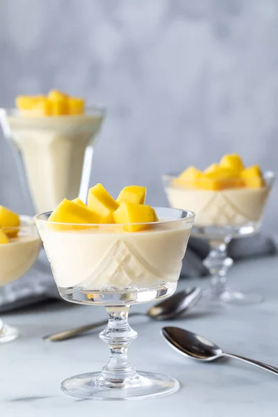 Großaufnahme mehrerer Mango-Mousse-Dessertparfaits vor grauem Hintergrund. — Stockfoto