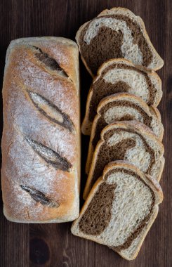 Dilimlenmemiş çavdar ekmeği ve yanında çavdar ekmeği dilimlenmiş vaziyette..