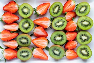 Kesilmiş kivi ve çilek sıraları. Ücretsiz meyve tatları.