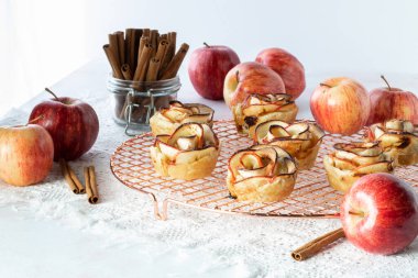 Elma ve tarçın çubuklarıyla çevrili bir soğutma rafında elmalı gülleri kapat..