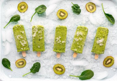 Kivi dilimleri ve ıspanak yapraklarıyla buzlu buzlu buzlu buzlu buzlu buzlu buzlu buzlu buzlu buzlu buzlu buzlu buzlu içeceklerin en üstten görünüşü..