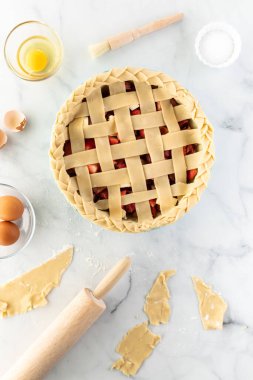 Pişirmek için fırına konmaya hazır çilekli turtanın yukarıdan aşağıya dikey görüntüsü.