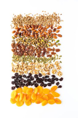 Çeşitli fındık, tohum ve kuru meyvenin beyaz arka planda karışık çerez yapımında kullanılan üst aşağı görünümü.